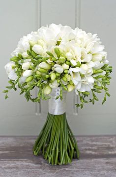 a bouquet of white flowers sitting on top of a table