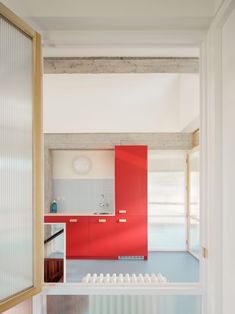 an open kitchen with red cabinets and white walls