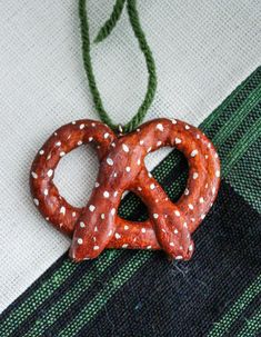 a pretzel ornament hanging from a string on a piece of cloth