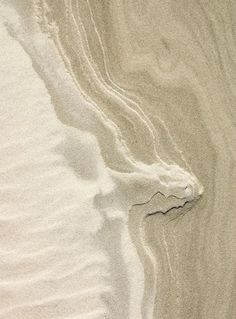 the sand is white and has waves in it