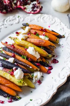 carrots with goat cheese and pomegranate on a white plate