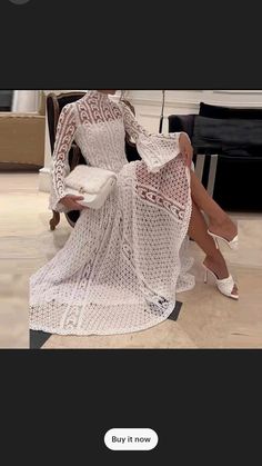 a woman sitting in a chair wearing a white dress