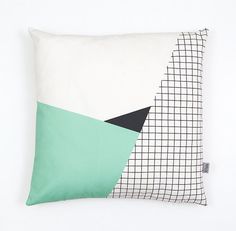 a white pillow with black and green squares on it