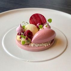 a white plate topped with a dessert covered in fruit