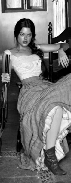 black and white photograph of a woman sitting on a chair with an umbrella in her hand