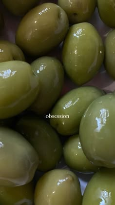 some green olives are sitting in a bowl on top of each other with the words,