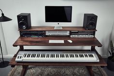 a computer desk with a keyboard, monitor and speakers