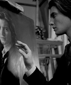 a man is looking at a portrait of himself