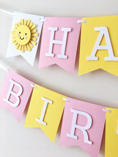 two paper banners with the words happy birthday and sun on them hanging from a wall