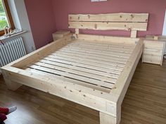 a wooden bed frame sitting on top of a hard wood floor