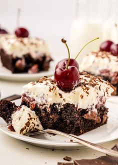 a piece of chocolate cake with whipped cream and cherries