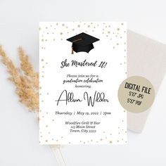 a graduation party card with gold stars and a black cap on it, next to a plant