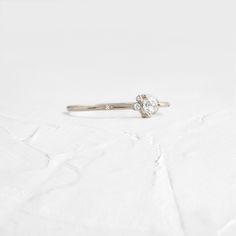 a diamond ring sitting on top of a white surface