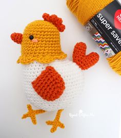 a crocheted chicken next to a ball of yarn