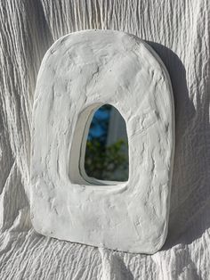 a white sculpture with a small window in it