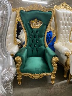 a green and gold chair sitting next to two white chairs in a room filled with other furniture