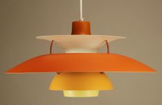 an orange and white lamp hanging from a ceiling