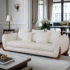 a living room filled with white furniture and lots of window sill space next to a fire place