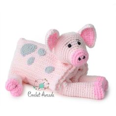 a crocheted pig laying on top of a blanket