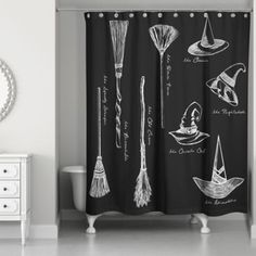 a bathroom with a black and white shower curtain that has various brooms on it