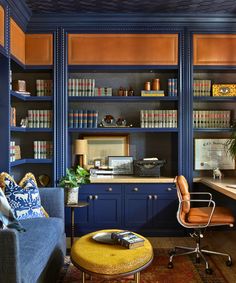 a living room filled with furniture and bookshelves next to a desk in front of a window