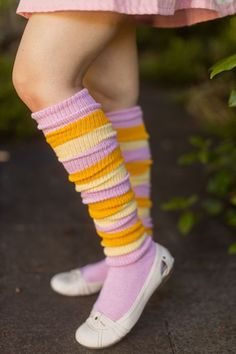 Brightly Colored, Orange, Pink, yellow striped thigh high socks scrunched down on the leg with white ballet flat shoes Cute Knee-high Socks For Spring, Cute Knee-high Spring Socks, Casual Striped Socks For Spring, Trendy Footless Socks For Spring, Spring One-size Knee-high Socks, Trendy Striped Socks For Spring, Trendy Footless Knee-high Socks For Spring, Trendy One-size Knee-high Socks For Spring, Fitted Yellow Socks For Spring