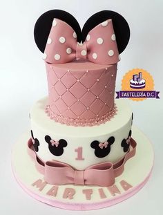 a minnie mouse cake is decorated with pink and white fondant