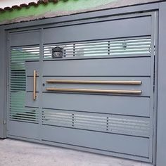 a grey garage door with gold handles and bars