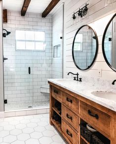 a bathroom with two sinks and mirrors on the wall