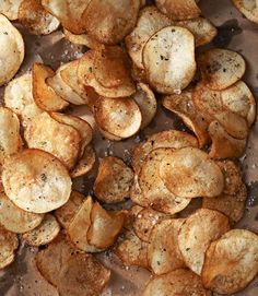 some potato chips are sitting on a sheet of tin foil and sprinkled with seasoning