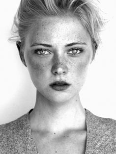 a black and white photo of a woman with freckled hair