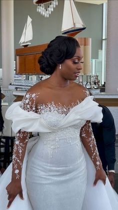 a woman in a white wedding dress standing next to a man