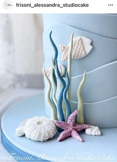 there is a blue cake decorated with sea animals and starfishs on it's side