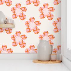 an orange and pink wallpaper with white vases on the counter next to it