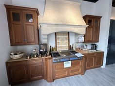 a large kitchen with wooden cabinets and a stove top oven in the middle of it