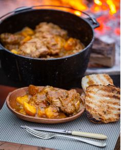 a bowl of stew next to some bread