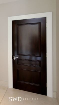 an empty room with a black door and tile floor