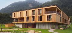 a large wooden building sitting on top of a lush green field