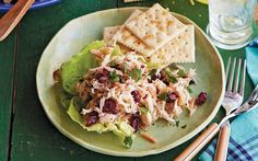 a green plate with crackers and salad on it