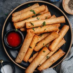 some food is on a black plate with sauces and spoons next to it