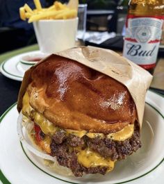 a cheeseburger on a plate with fries and beer