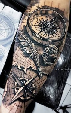 a man's arm with a compass and an arrow tattoo on the left forearm