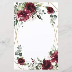 a white card with red flowers and greenery on the bottom, in front of a marble background