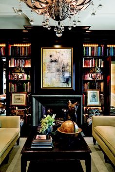 a living room filled with lots of furniture and a fire place under a chandelier