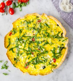 an omelet with spinach and tomatoes on the side next to other ingredients