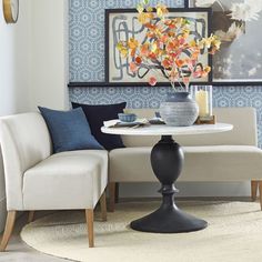 a living room with blue and white wallpaper on the walls next to a round table