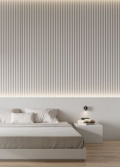 a white bed sitting in a bedroom next to a wall with vertical blinds on it