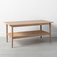 a wooden table sitting on top of a hard wood floor next to a white wall