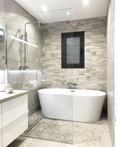 a white bath tub sitting inside of a bathroom next to a walk in shower stall