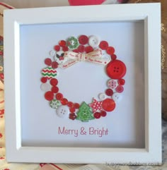 a white frame with buttons and bows in the shape of a christmas ornament